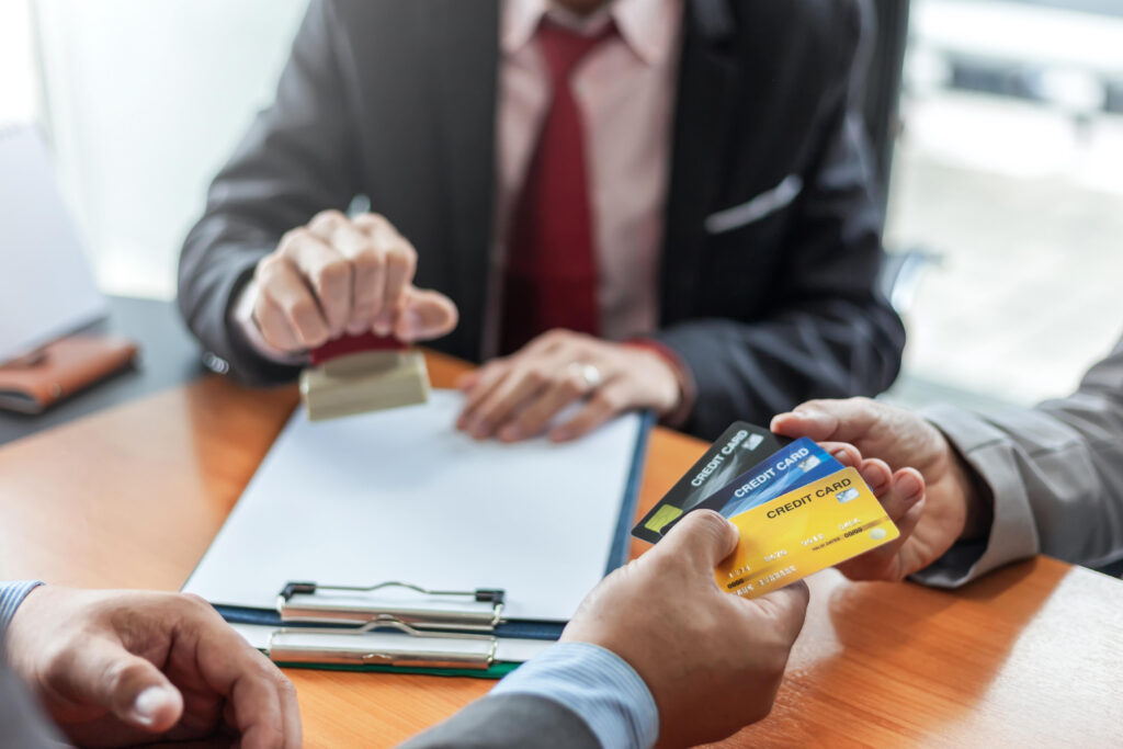 Profesionales revisando un contrato y tarjetas de crédito para proteger una empresa frente a impagos