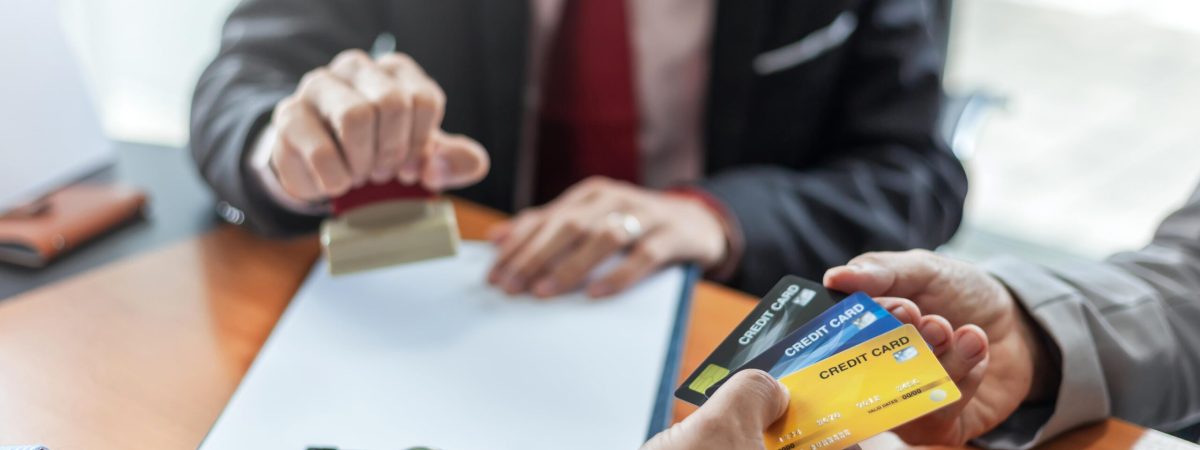 Profesionales revisando un contrato y tarjetas de crédito para proteger una empresa frente a impagos